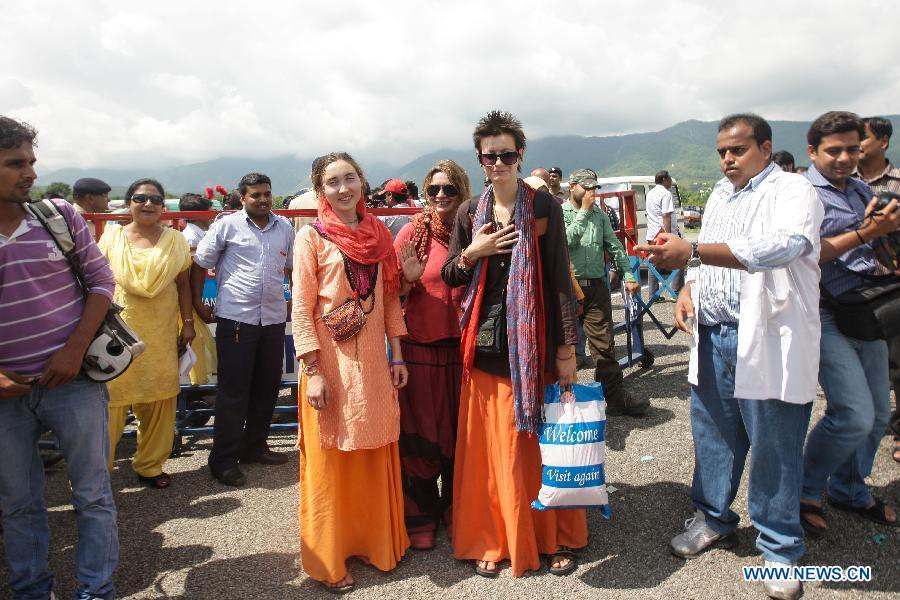 Flood-stranded foreign tourists arrive at a helicopter airport in Dehradun, northern Indian state of Uttarakhand, June 26, 2013. There are still an estimated 7000 people stranded in the flood while authorities use military planes and helicopters in the rescue in flood-ravaged northern India. (Xinhua/Zheng Huansong) 