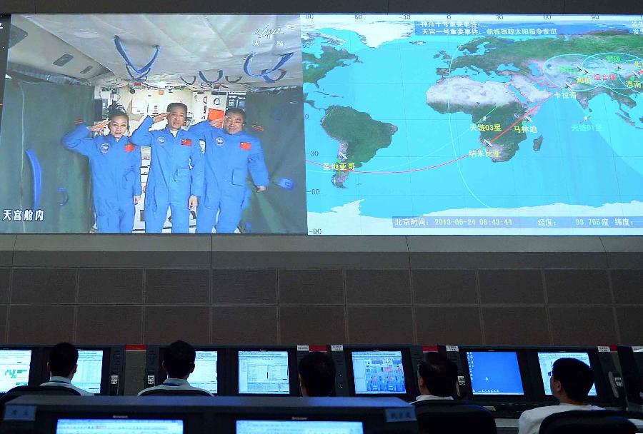 Photo taken on June 24, 2013 shows the screen at the Beijing Aerospace Control Center showing astronauts Nie Haisheng (C), Zhang Xiaoguang (R) and Wang Yaping saluting in Tiangong-1 space lab module. Chinese President Xi Jinping came to the Beijing Aerospace Control Center Monday morning to talk with the astronauts aboard Tiangong-1. (Xinhua/Li Tao)