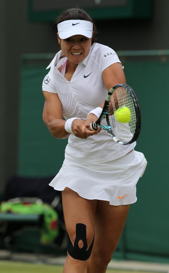 Li Na of China returns the ball during the second round of ladies' singles against Simona Halep of Romania on day 4 of the Wimbledon Lawn Tennis Championships at the All England Lawn Tennis and Croquet Club in London, Britain on June 27, 2013. Li won 2-1. (Xinhua/Yin Gang)