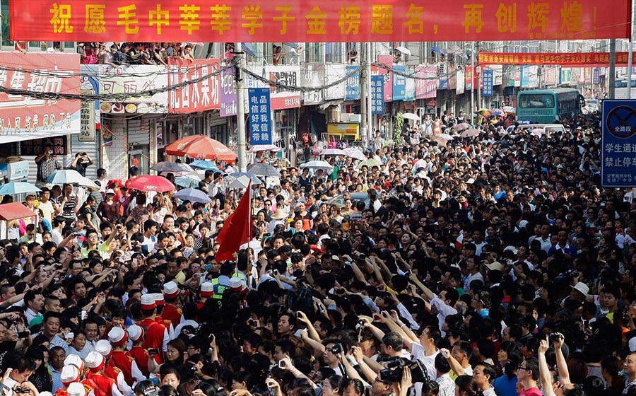 Parents send students to take the university entrance examination outside a middle school in Anhui province on June 5, 2013. (Photo/CNTV) 