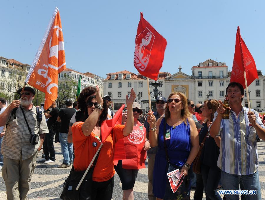 People pass by a closed metro station in Lisbon, June 27, 2013. The Portuguese staged a general strike across the country on Thursday fuelled by the prolonged economic recession in the bailed-out country. Meanwhile, thousands of Portuguese in Lisbon took to the street protesting against the government's austerity measures. (Xinhua/Zhang Liyun) 