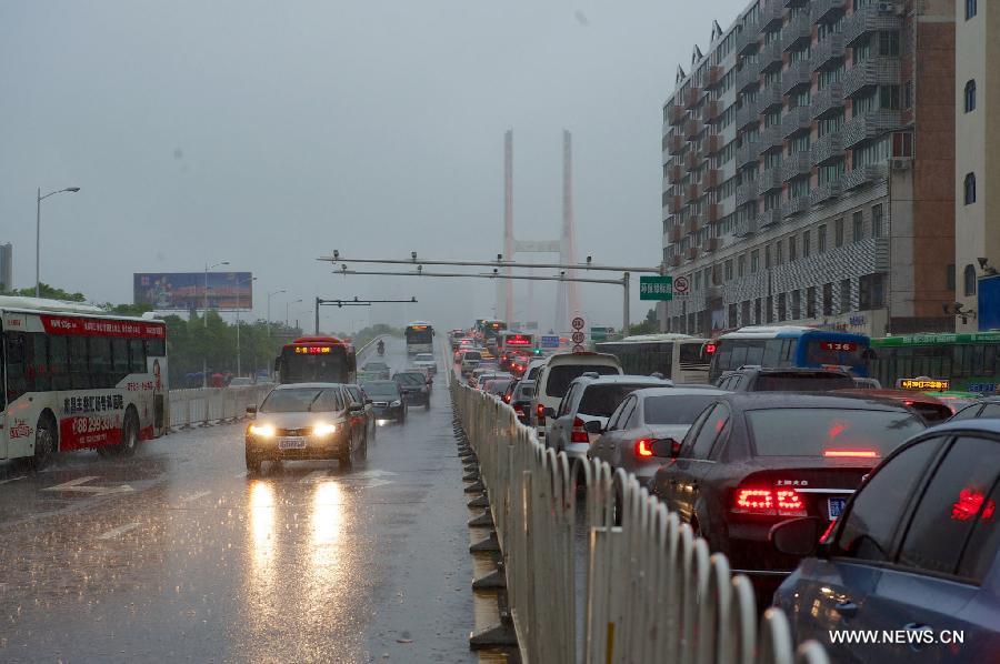 Vehicles run on a waterlogged road in rain in Nanchang, capital of east China's Jiangxi Province, June 28, 2013. Heavy rainfall hit parts of the province on Friday. (Xinhua/Hu Chenhuan) 