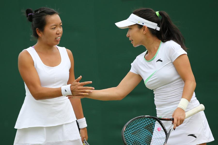 Zheng Jie (R) of China and Vania King of the United States react during the first round match of women's doubles against Vesna Dolonc/Bojana Jovanovski of Serbia on day 4 of the Wimbledon Lawn Tennis Championships at the All England Lawn Tennis and Croquet Club in London, Britain, on June 27, 2013. Zheng Jie/Vania King won 2-0. (Xinhua/Yin Gang)