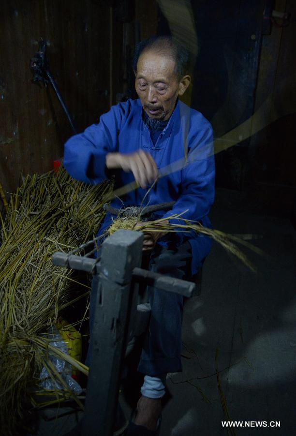 A man named Zhang Chengyu weaves straw sandals at Jinlongba Village in Enshi City, central China's Hubei Province, June 27, 2013. The Jinlongba Village was listed among the 646 Chinese Traditional Villages in 2012 and villagers here followed the traditional way of living. (Xinhua/Yang Shunpi)  