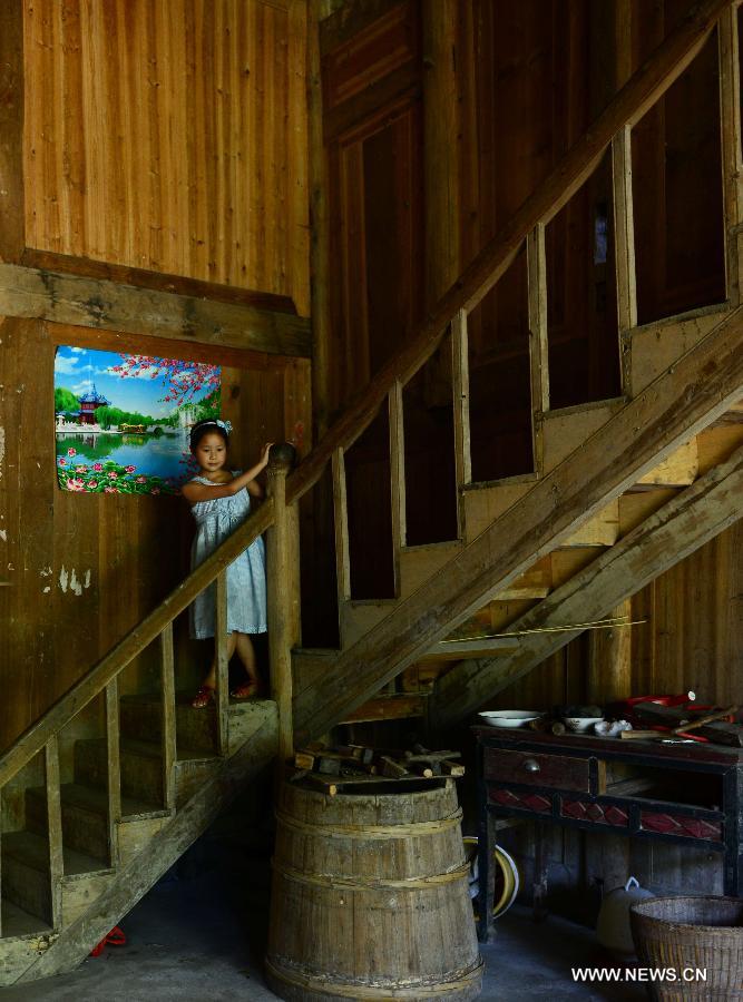 A child plays games on stairs at Jinlongba Village in Enshi City, central China's Hubei Province, June 27, 2013. The Jinlongba Village was listed among the 646 Chinese Traditional Villages in 2012 and villagers here followed the traditional way of living. (Xinhua/Yang Shunpi)  