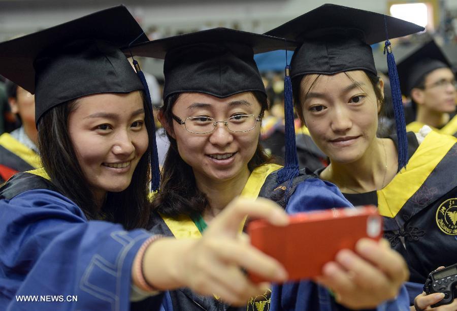 Graduates pose for a group photo during the graduation ceremony of Zhejiang University in Hangzhou, capital of east China's Zhejiang Province, June 29, 2013. The graduation ceremony was held here Saturday. (Xinhua/Han Chuanhao)