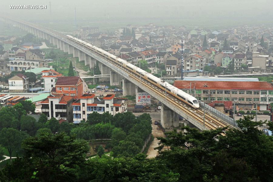 A bullet train runs during its trial trip in Shangyu City, east China's Zhejiang Province, June 29, 2013. A new high-speed railway that stretches across east China's Yangtze River Delta is scheduled to go into commercial service on July 1. The Nanjing-Hangzhou-Ningbo high-speed railway, with a designated top speed of 350 km per hour, will cut travel time between Nanjing, capital of east China's Jiangsu Province, and the port city of Ningbo in east China's Zhejiang Province to about two hours. High-speed trains will run at a speed of 300 km per hour during the initial operation period. (Xinhua/Tan Jin)