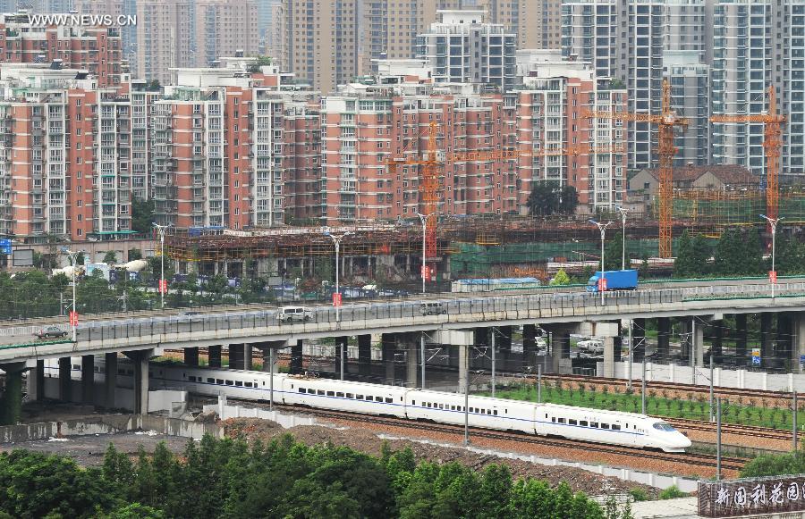 A bullet train runs during its trial trip in Hangzhou City, capital of east China's Zhejiang Province, June 30, 2013. A new high-speed railway that stretches across east China's Yangtze River Delta is scheduled to go into commercial service on July 1. The Nanjing-Hangzhou-Ningbo high-speed railway, with a designated top speed of 350 km per hour, will cut travel time between Nanjing, capital of east China's Jiangsu Province, and the port city of Ningbo in east China's Zhejiang Province to about two hours. High-speed trains will run at a speed of 300 km per hour during the initial operation period. (Xinhua/Tan Jin)