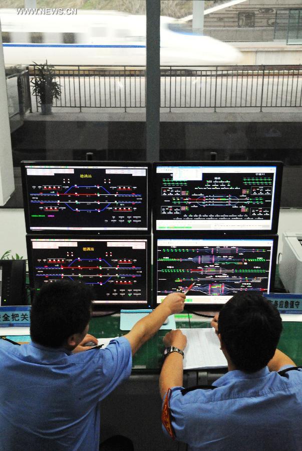 Working staff monitor the operation process of bullet trains during their trial trip at the Deqing Station in east China's Zhejiang Province, June 28, 2013. A new high-speed railway that stretches across east China's Yangtze River Delta is scheduled to go into commercial service on July 1. The Nanjing-Hangzhou-Ningbo high-speed railway, with a designated top speed of 350 km per hour, will cut travel time between Nanjing, capital of east China's Jiangsu Province, and the port city of Ningbo in east China's Zhejiang Province to about two hours. High-speed trains will run at a speed of 300 km per hour during the initial operation period. (Xinhua/Tan Jin)