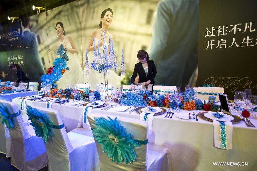 A staff member places utensils for wedding feast at the wedding expo in Beijing, capital of China, June 28, 2013. The three-day 2013 China (summer) wedding expo kicked off here on Friday. Some 3,000 exhibitors from over 30 countries and regions participated in the exposition. (Xinhua/Zhao Bing) 