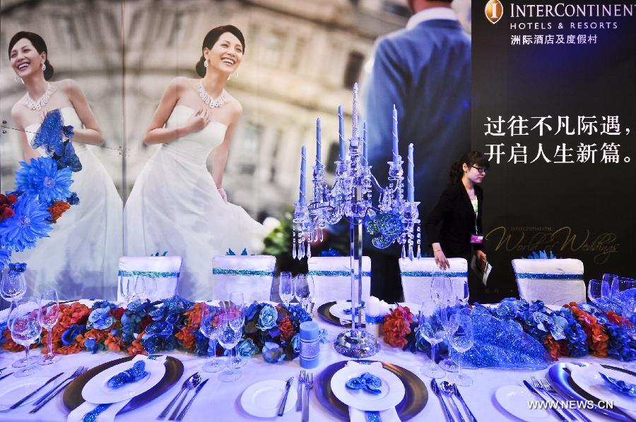 A staff member places utensils for wedding feast at the wedding expo in Beijing, capital of China, June 28, 2013. The three-day 2013 China (summer) wedding expo kicked off here on Friday. Some 3,000 exhibitors from over 30 countries and regions participated in the exposition. (Xinhua/Wang Jingsheng) 