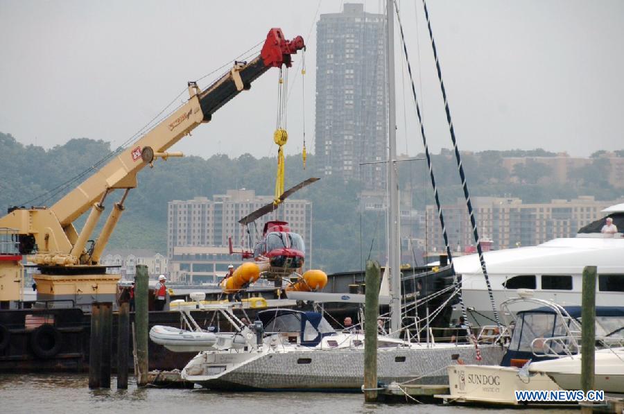 A helicopter is seen lifted from the Hudson River by a crane off Manhattan, New York, the United States, June 30, 2013. The helicopter carrying four tourists made an emergency landing on Saturday in the Hudson River with no casualty. (Xinhua/David Torres)