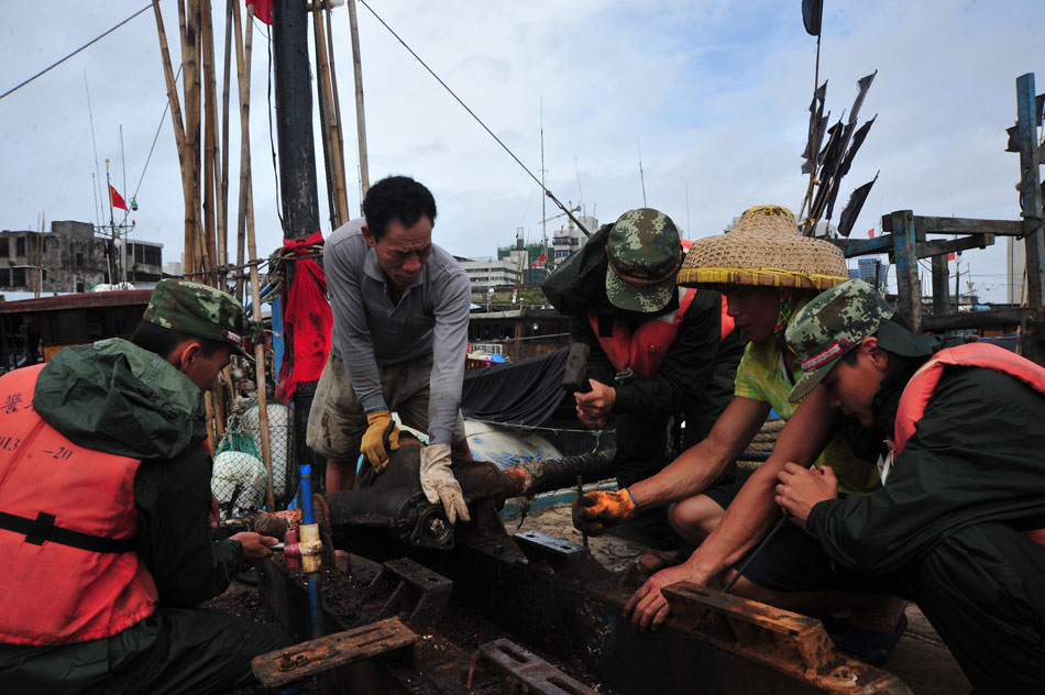 Coast guards help the fishermen fasten the fishing boats in Haikou City, capital of south China's Hainan Province, June 22, 2013. Tropical storm "Bebinca" was estimated to arrive in south China's Guangdong Province on the afternoon. Affected by the tropical storm, coastal areas in Hainan and Guangdong provinces were battered by gales and torrential rain. (Photo/Xinhua)