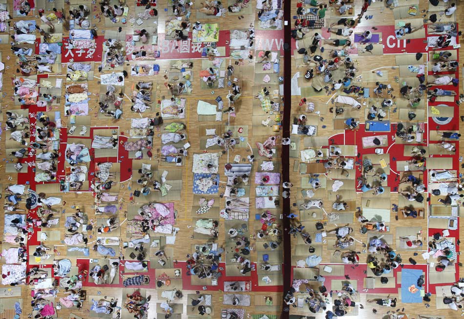 Students of Huazhong Normal University enjoy the cool air provided by air conditioning in the stadium on June 21, 2013. As temperature remained high in Wuhan, Huazhong University opened its stadium with air conditioning to students. (Xinhua/Chen Zhuo)