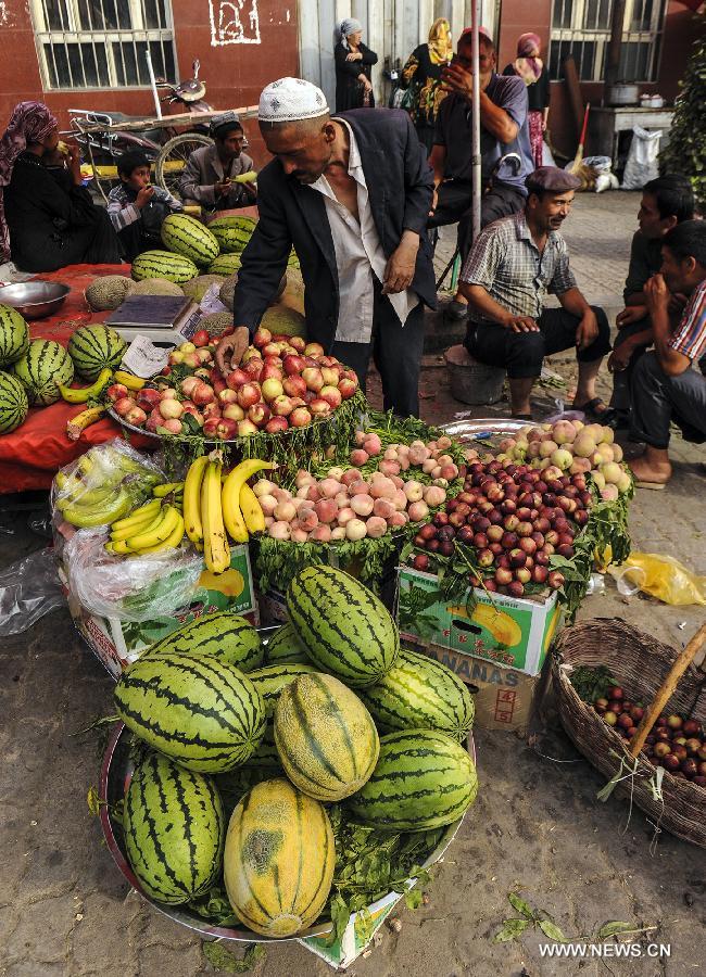 A farmer sells fruits at Kashi Grand Bazzar in Kashi Prefecture, northwest China's Xinjiang Uygur Autonomous Region, June 30, 2013. Kashi Grand Bazzar is the largest international business market in China's northwest region. Bazzar in Uygur language means market or fair. (Xinhua/Shen Qiao)