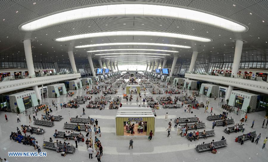 Passengers are seen at the newly-opened Hangzhou East Station in Hangzhou, capital of east China's Zhejiang Province, July 1, 2013. With the building area of 1.13 million square meters, the Hangzhou East Station, China's largest railway terminal, officially opened on Monday. (Xinhua/Zhu Yinwei)