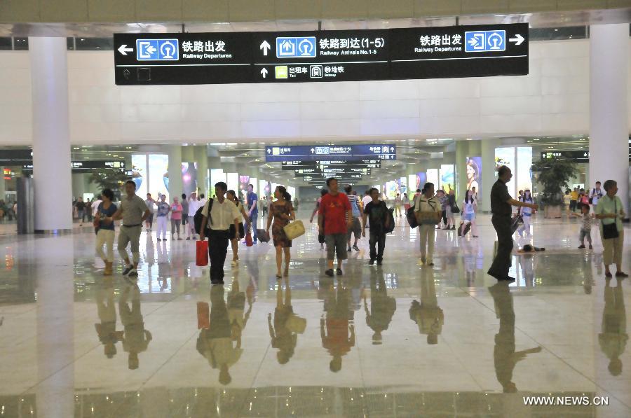 People walk inside the newly-opened Hangzhou East Station in Hangzhou, capital of east China's Zhejiang Province, July 1, 2013. With the building area of 1.13 million square meters, the Hangzhou East Station, China's largest railway terminal, officially opened on Monday. (Xinhua/Zhu Yinwei) 
