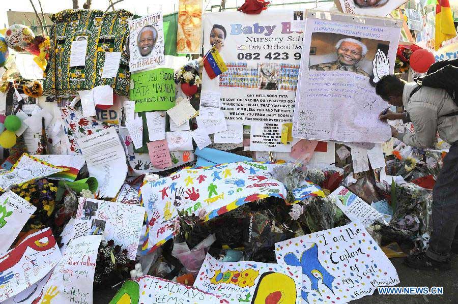 A local resident writes his wishes outside the hospital where South Africa's anti-apartheid icon Nelson Mandela is treated in Pretoria, South Africa, to pray for Mandela, July 1, 2013. (Xinhua/Li Qihua)