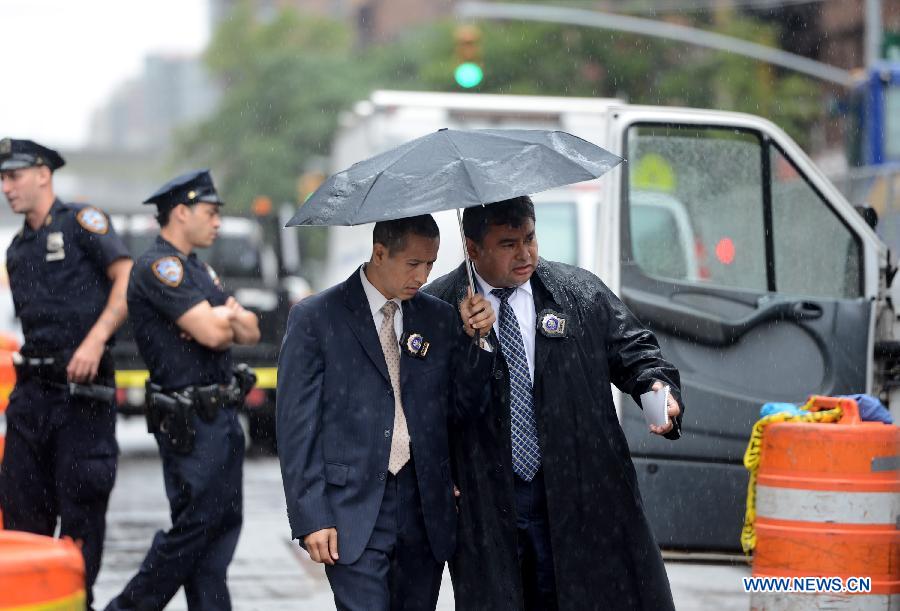 Detectives investigates at the crime scene in New York, the United States, on July 1, 2013. The male victim, a 56-year-old construction worker, was shot in the chest on West 49th Street and Ninth Avenue around 9 a.m. The victim was taken to Roosevelt Hospital. The suspect, believed to be an ex-employee of the same construction compnay, fled the scene in a white vehicle. He is considered armed and dangerous, according to the police. (Xinhua/Wang Lei)