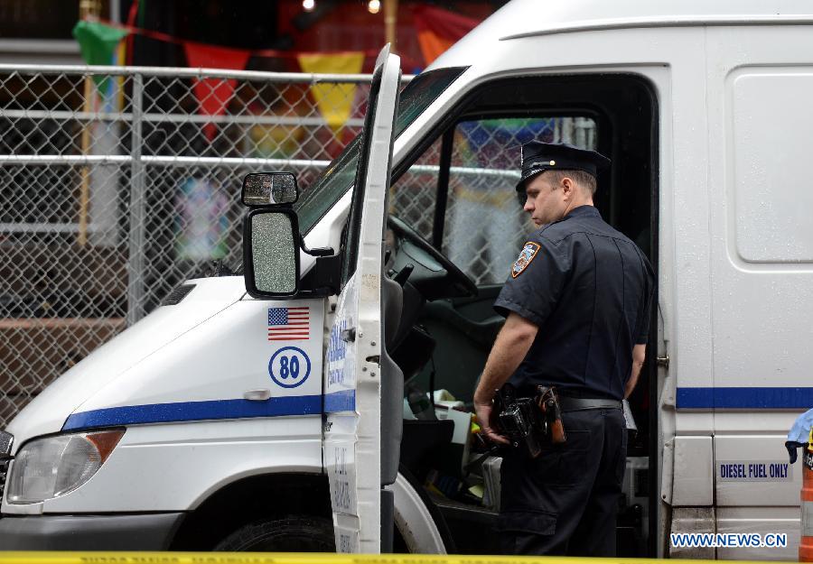 A police officer investigates an involved vehicle at the crime scene in New York, the United States, on July 1, 2013. The male victim, a 56-year-old construction worker, was shot in the chest on West 49th Street and Ninth Avenue around 9 a.m. The victim was taken to Roosevelt Hospital. The suspect, believed to be an ex-employee of the same construction compnay, fled the scene in a white vehicle. He is considered armed and dangerous, according to the police. (Xinhua/Wang Lei)