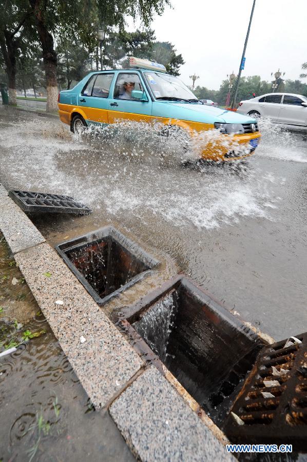 A taxi pass throuth a waterlogged road in Changchun, capital of northeast China's Jilin Province, July 2, 2013. Heavy rain h+as hit Jilin in recent days. (Xinhua/Zhang Nan)