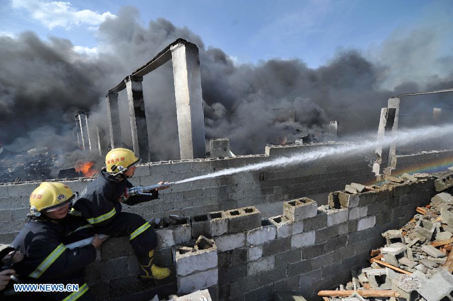 Firemen spray water to control a fire at a warehouse near the Changsha South Railway Station in Changsha, capital of central China's Hunan Province, July 2, 2013. A fire engulfed the warehouse Sunday without injuring anyone. Local fire department took more than two hours to douse the fire. (Xinhua/Li Ga) 