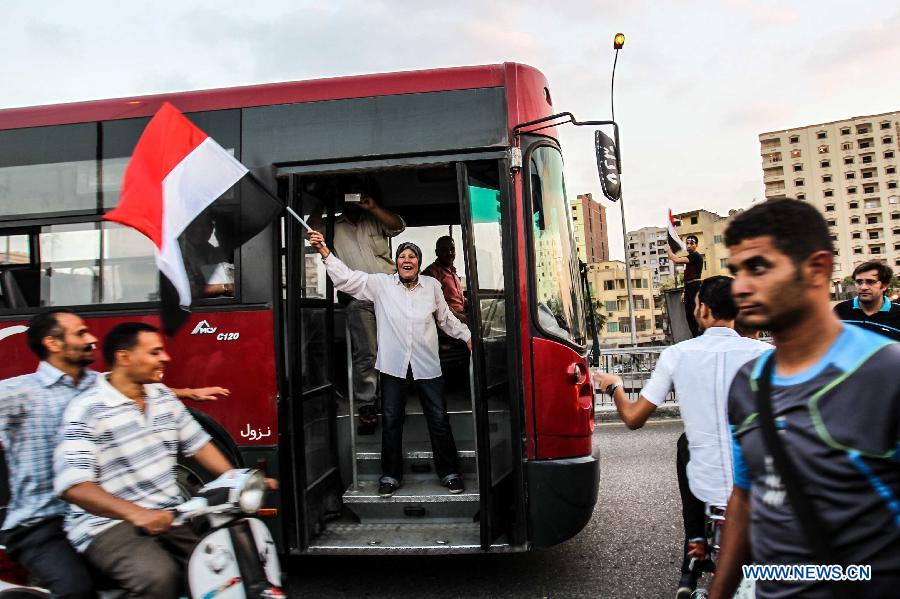 An Egyptian woman waves the Egyptian flag and chanting anti-Morsi slogans during an opposition rally in front of Al-Qoba presidential palace in Cairo, Egypt, July 2, 2013. Egyptian President Mohamed Morsi said late Tuesday that there will be no alternative for "constitutional legitimacy," amid the ongoing political division in his country, where the opposition and liberal are asking him to quit power. (Xinhua/Amru Salahuddien)