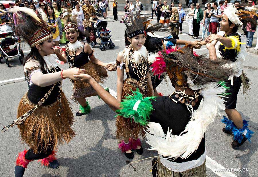 People dance in a parade as a part of Canada Day celebrations in Montreal, Canada, on July 1, 2013. Celebrations were held across the country to mark the 146th anniversary of Canada's foundation. (Xinhua/Andrew Soong) 