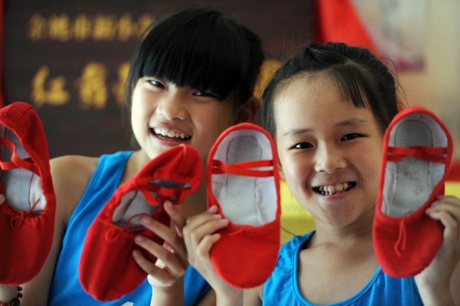 Girls wear red dance shoes at summer dance camp Red Shoes in Yuyao city, Zhejiang province, July 2, 2013. (Photo:Chen Binrong/Xinhua)