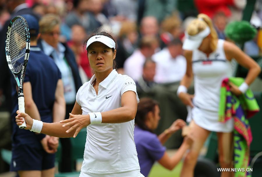 Li Na (L) of China practises as Agnieszka Radwanska of Poland receives medical treatment during the quarterfinal of women's singles on day 8 of the Wimbledon Lawn Tennis Championships at the All England Lawn Tennis and Croquet Club in London, Britain on July 2, 2013. Li Na lost 1-2. (Xinhua/Yin Gang)