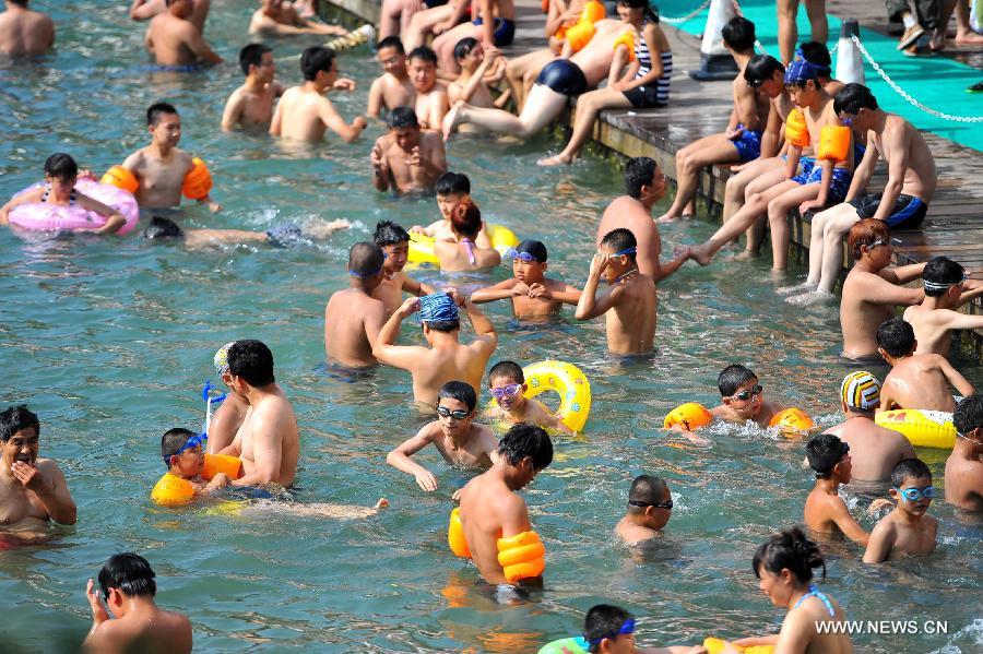 Citizens enjoy coolness at an outdoor bathing place in Jinan, capital of east China's Shandong Province, July 3, 2013. The highest temperature in Jinan reached 38 degrees celsius on Wednesday. (Xinhua/Guo Xulei)