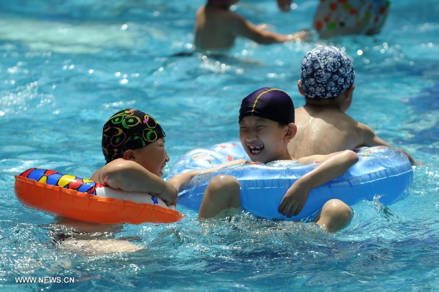 Citizens enjoy coolness at a natatorium in Shijiazhuang, capital of north China's Hebei Province, July 3, 2013. The highest temperatures in many parts of Hebei reached 37 degrees celsius on Wednesday. (Xinhua/Wang Xiao)