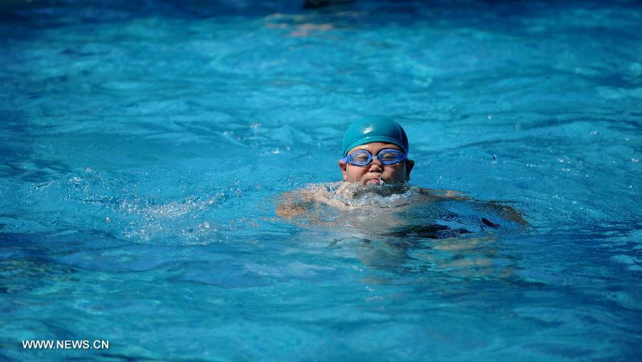 A child swims at a natatorium in Shijiazhuang, capital of north China's Hebei Province, July 3, 2013. The highest temperatures in many parts of Hebei reached 37 degrees celsius on Wednesday. (Xinhua/Wang Xiao)