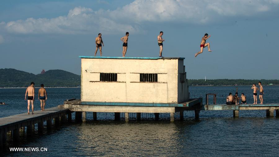 People enjoy coolness at the East Lake in Wuhan, capital of central China's Hubei Province, July 3, 2013. The highest temperature in Wuhan reached 36 degrees celsius on Wednesday. (Xinhua/Cheng Min)