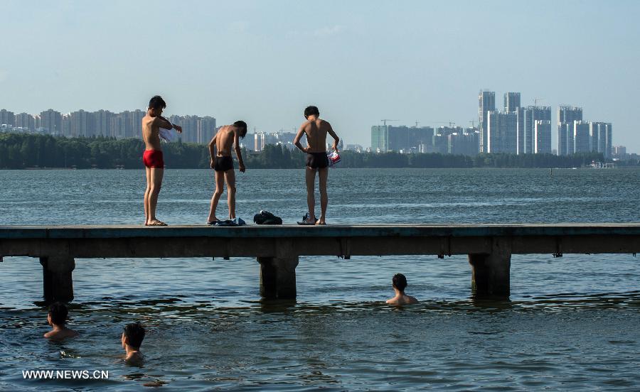 People enjoy coolness at the East Lake in Wuhan, capital of central China's Hubei Province, July 3, 2013. The highest temperature in Wuhan reached 36 degrees celsius on Wednesday. (Xinhua/Cheng Min)