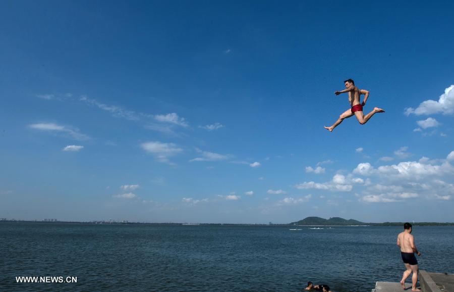 A man jumps into the water at the East Lake in Wuhan, capital of central China's Hubei Province, July 3, 2013. The highest temperature in Wuhan reached 36 degrees celsius on Wednesday. (Xinhua/Cheng Min)