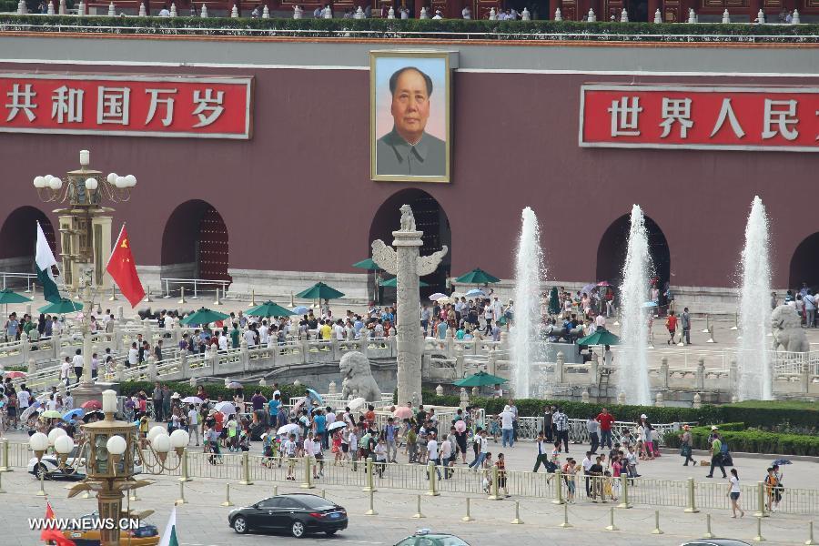 Visitors tour at the Tian'anmen Square in Beijing, capital of China, July 3, 2013. The highest temperatures in many parts of Beijing reached 35 degrees celsius on Wednesday. (Xinhua/Xing Guangli)