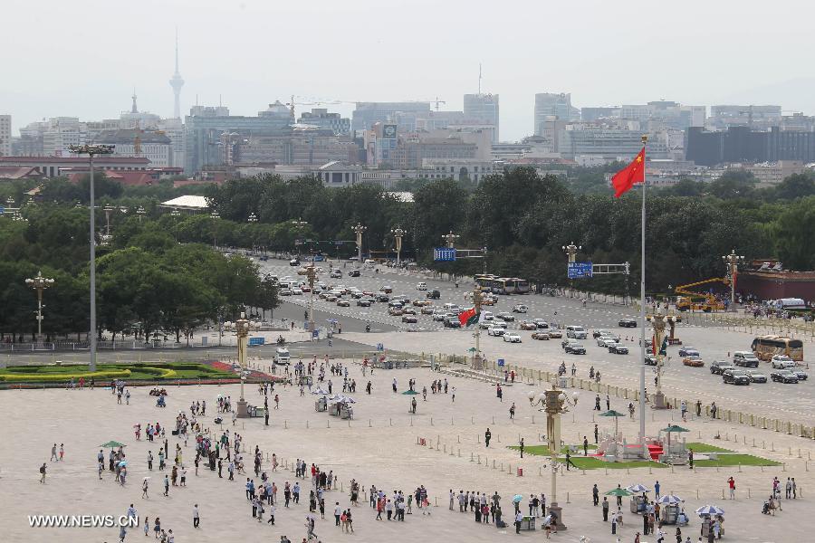 Visitors tour at the Tian'anmen Square in Beijing, capital of China, July 3, 2013. The highest temperatures in many parts of Beijing reached 35 degrees celsius on Wednesday. (Xinhua/Xing Guangli)