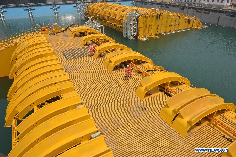 Wokers check newly-built deep-sea engineering equipment in Qingdao, east China's Shandong Province, July 3, 2013. (Xinhua/Wan Houde)