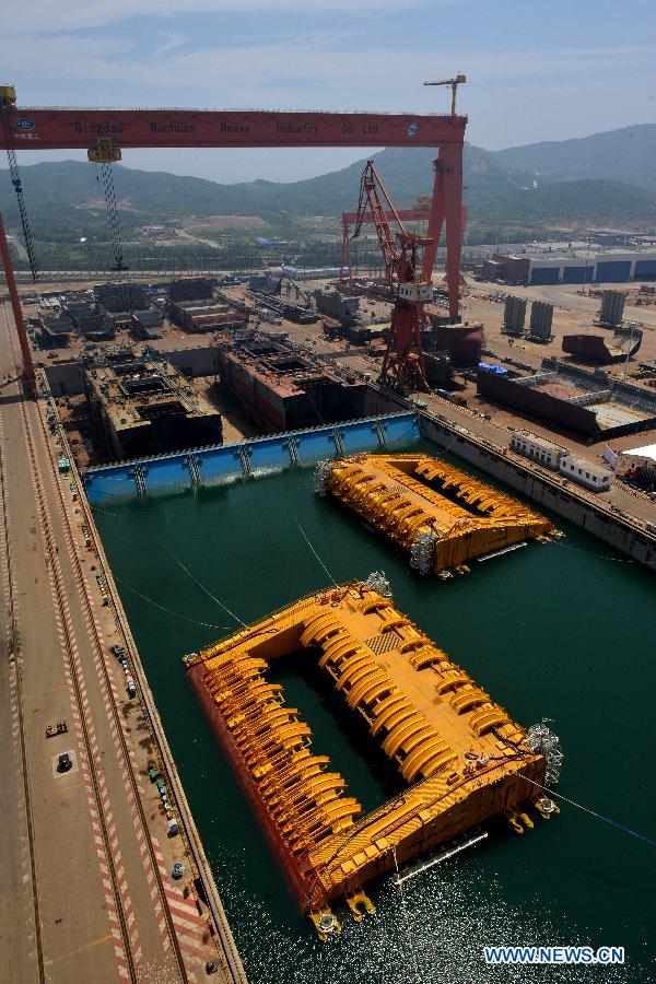 Photo taken on July 3, 2013 shows buoys of the newly-built deep-sea engineering equipment in Qingdao, east China's Shandong Province. With four sets of buoys and 16 sets of foundations, the deep-sea engineering equipment, the world's largest of this kind, was built and delivered by Wuchang Shipbuilding Industry Co., Ltd. to Petrobras as part of the Sapinhoa-Lula NE BSR Buoys & Foundations Project, which will be installed in an offshore oilfield in Brazil to work for a period of 27 years. The equipment is able to fit in deeper and more complicated marine environment and has extensively enlarged the scope of offshore oil exploitation, said Victor Bomfim, senior vice president of the project contractor Subsea 7 S.A. (Xinhua/Wan Houde)