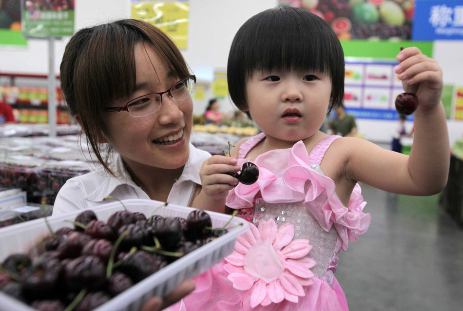 A child tries US cherries at a Sam's Club in Beijing. As cherries become increasingly popular in China, so have imports of US cherries, which were worth $75 million in 2012. [Photo / China Daily] 