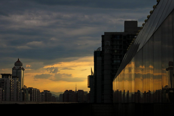 One view of city buildings at sunset after a brief thunderstorm hit Beijing, July 4, 2013.(Photo/Xinhua)