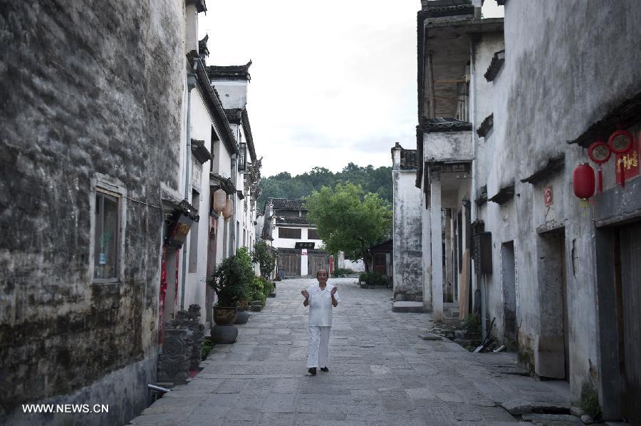 A local resident takes his morning exercises at Hongcun, an ancient village founded in 1131 in Huangshan City, east China's Anhui Province, early July 3, 2013. Listed as a world cultural heritage site, the village preserved to a remarkable extent the surviving examples of Anhui-style architecture and traditional lifestyle. (Xinhua/Guo Chen) 