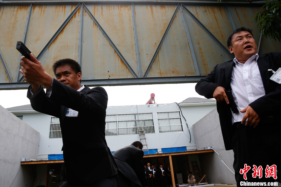 Trainees receive the tactical shooting training during a VIP security training course in Lianyungang, east China's Jiangsu province, June 30, 2013. (Chinanews/Liu Guanguan)