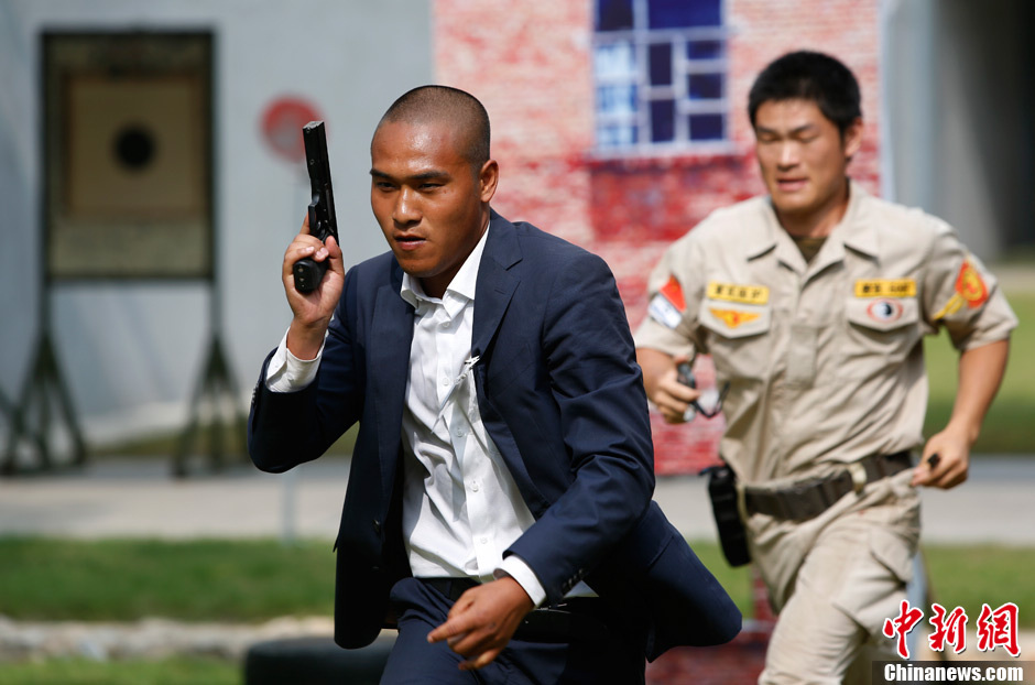 Trainees receive the tactical shooting training during a VIP security training course in Lianyungang, east China's Jiangsu province, June 30, 2013. (Chinanews/Liu Guanguan)