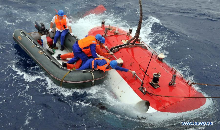 Working staff untie the rope on the China's manned submersible Jiaolong in the south China Sea, July 5, 2013. The Jiaolong manned submersible on Friday carried out a scientific dive to collect rock samples from the Jiaolong Seamount in the South China Sea. (Xinhua/Zhang Xudong)