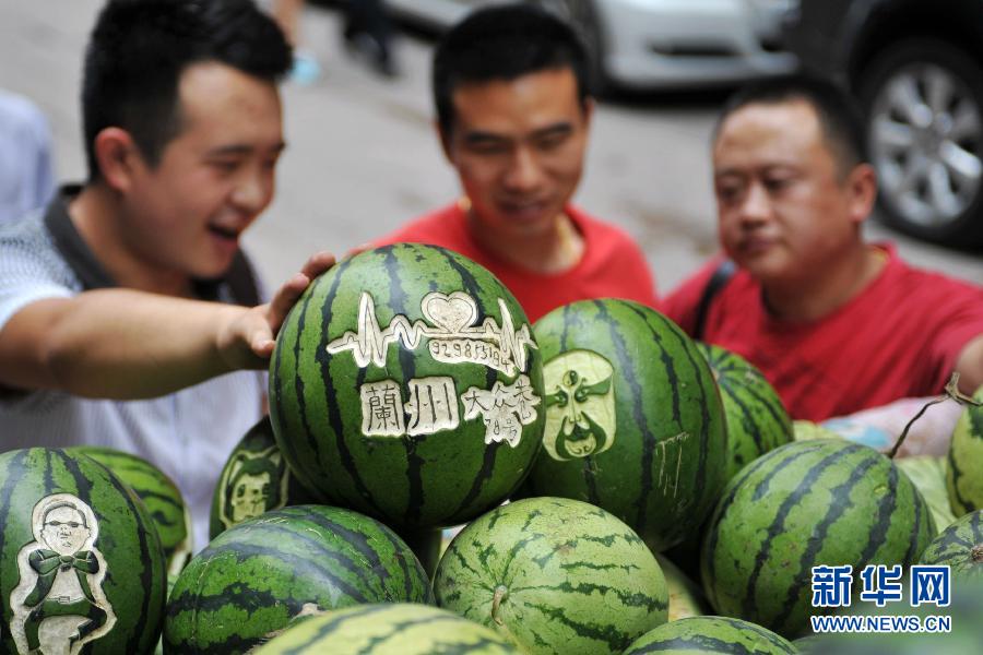 Some citizens choose watermelons at Shen Dongbin's stall in northwest China's Lanzhou on July 4, 2013. (Photo/Xinhua)