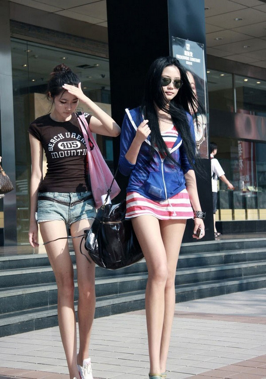 Two women wearing mini-skirts walking on the street in Sichuan. (Xinhuanet.com )