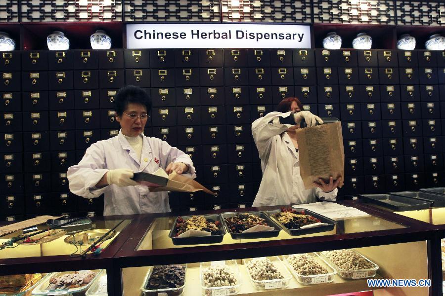 Two pharmacists prepare medicine for the customers at the Beijing Tong Ren Tang Cabramatta Store, southeast of Sydney, Australia, on July 5, 2013. Beijing Tong Ren Tang Cabramatta Store opened on July 5, 2013, the fourth store in Australia following the stores in Sydney CBD in 2005,, Brisbane in 2008 and Chatswood, north of Sydney in 2011. Australia legalized traditional Chinese medicine in 2012. Beijing TRT founded in 1669 is a famous time-honored brand in traditional Chinese medicine industry. (Xinhua/Jin Linpeng)