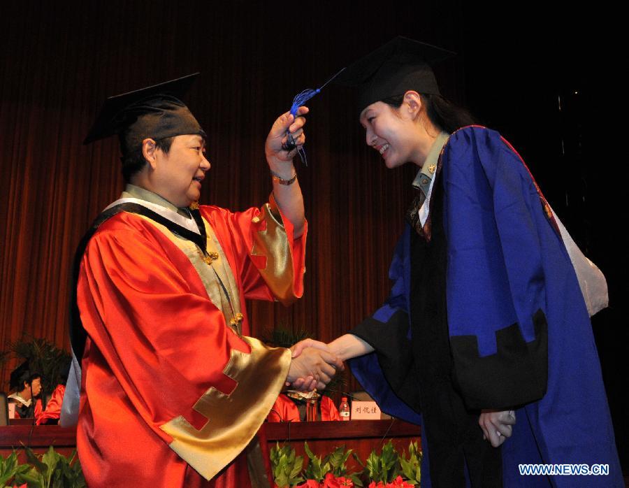 Zhao Yimin (L), acting president of the university, attends the graduation ceremony in the Fourth Military Medical University in Xi'an, northwest China's Shaanxi Province, July 5, 2013. Altogether 245 Ph.D. students and 575 postgraduate students graduated from the university this year. (Xinhua/Ding Haitao)